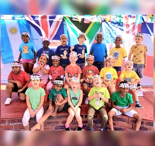 Children standing together, smiling for a photo with bright flags behind them, creating a cheerful atmosphere. Children standing together, smiling for a photo with bright flags behind them, creating a cheerful atmosphere.